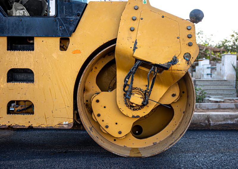 Road roller makes the paving. Road roller compacting asphalt. Roller Compactor on Fresh Asphalt.